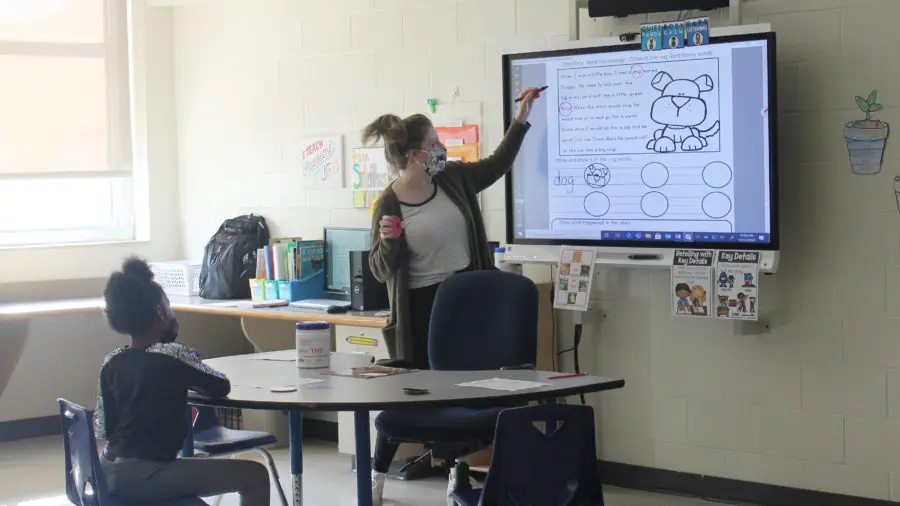 friendship academy student learning with teacher via a SmartBoard in the classroom