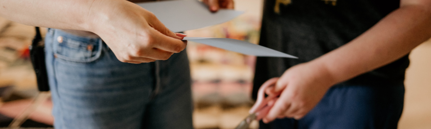 close up image of teacher and student's hands holding school supplies