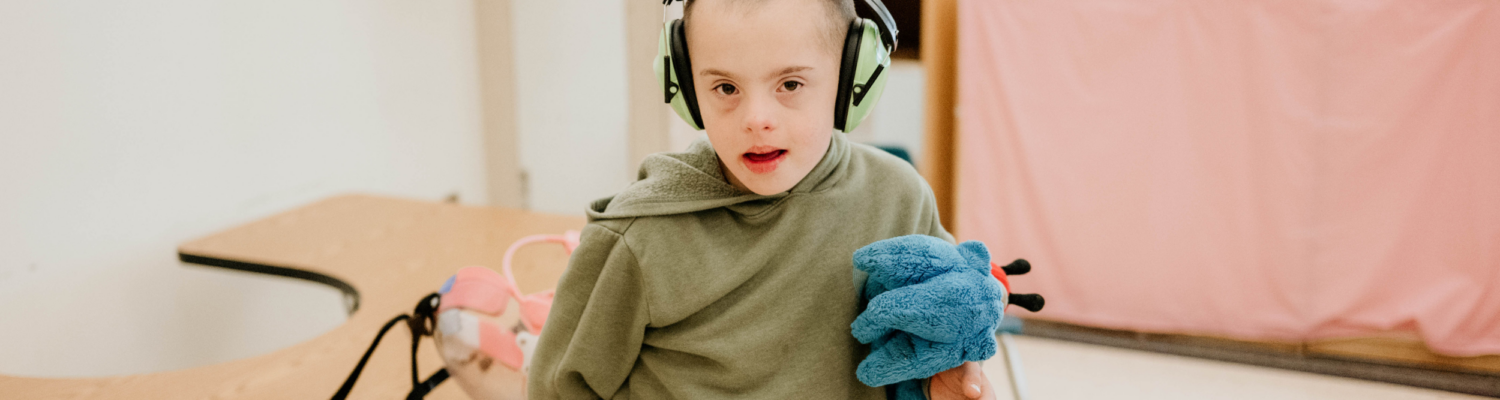 young boy with special needs pictured smiling in his classroom