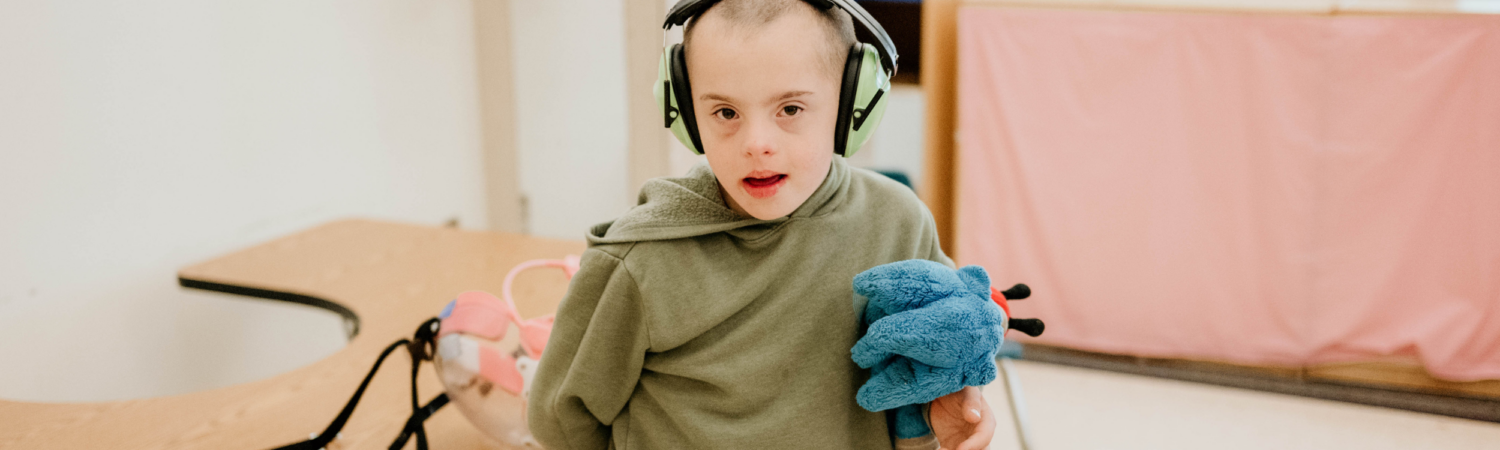 young boy with special needs pictured smiling in his classroom