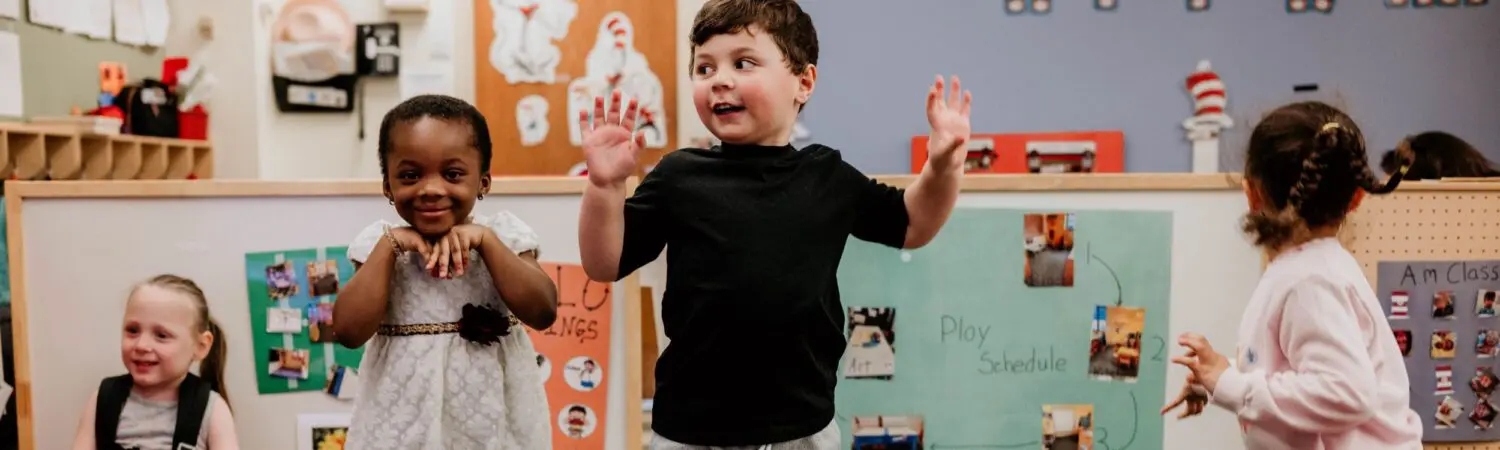 young preschool students pictured jumping around their classroom